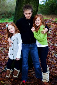 siblings leaning on tree